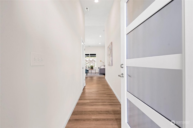 hall featuring wood finished floors and recessed lighting