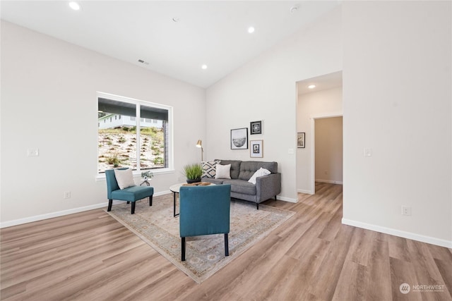 sitting room featuring baseboards, visible vents, light wood-style floors, high vaulted ceiling, and recessed lighting