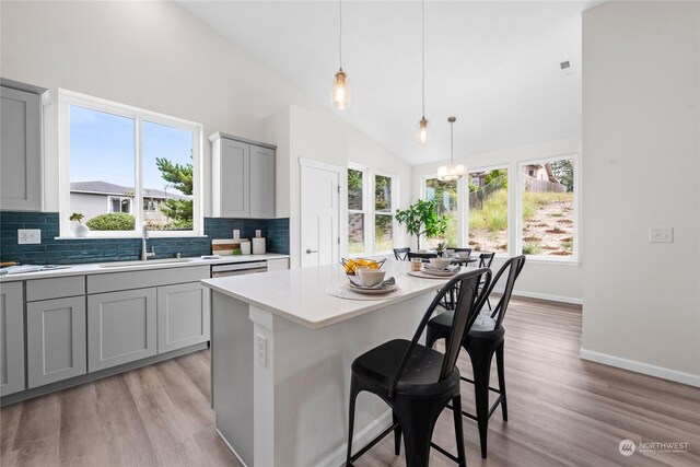 kitchen with light hardwood / wood-style floors, tasteful backsplash, and a healthy amount of sunlight