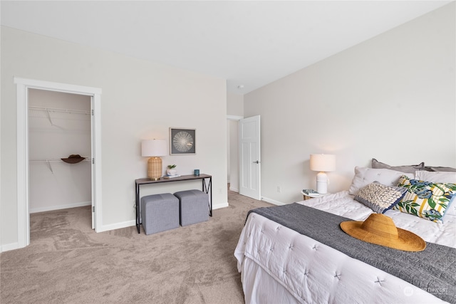 bedroom with a walk in closet, light colored carpet, and a closet