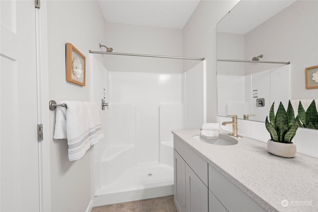 bathroom featuring tile patterned floors, vanity, and walk in shower