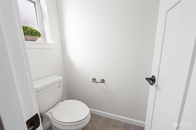 bathroom featuring toilet and baseboards