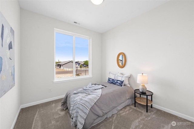 carpeted bedroom with visible vents and baseboards