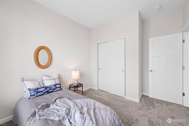 bedroom with a closet, carpet flooring, and baseboards