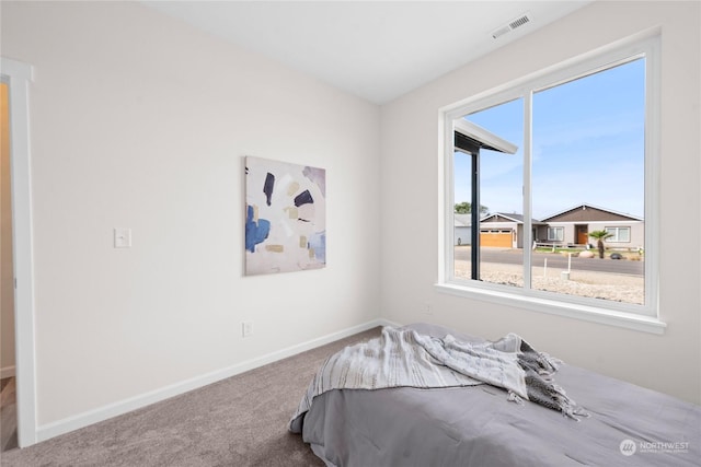 bedroom featuring carpet floors, visible vents, and baseboards