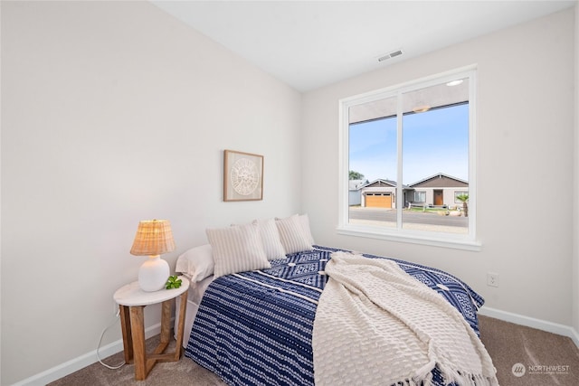 carpeted bedroom featuring visible vents and baseboards