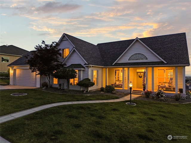 view of front of property featuring a yard, covered porch, and a garage