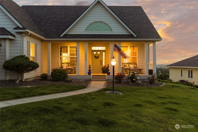 view of front of house with a porch and a yard