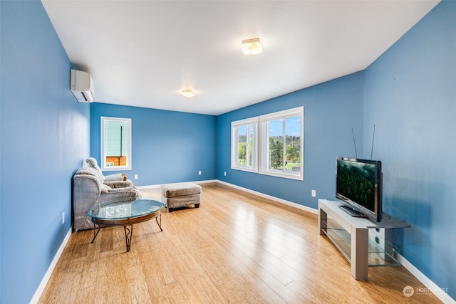 sitting room with light hardwood / wood-style flooring and a wall mounted air conditioner