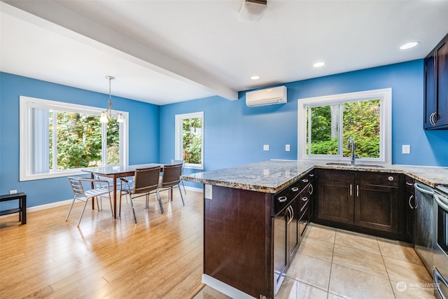 kitchen with a wealth of natural light, light hardwood / wood-style floors, hanging light fixtures, and a wall mounted AC