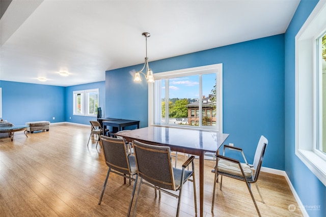 dining space featuring light hardwood / wood-style flooring and a chandelier