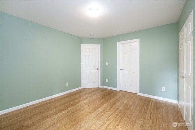 unfurnished bedroom with light wood-type flooring and a closet