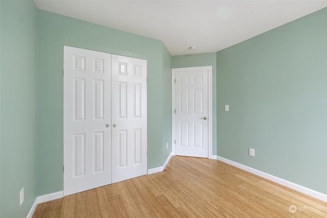 unfurnished bedroom with wood-type flooring and a closet