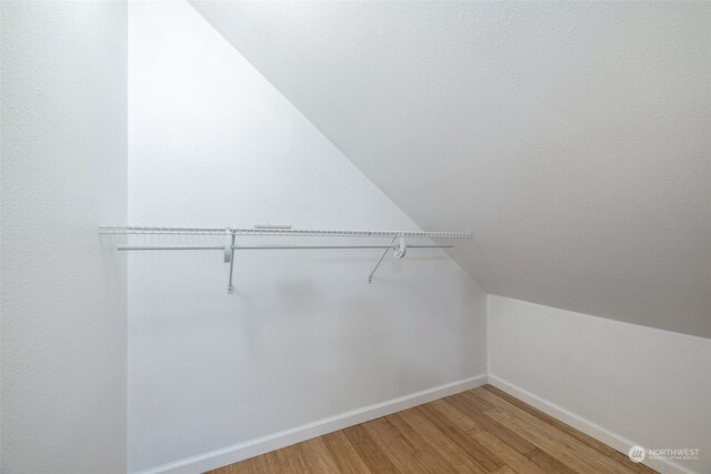 spacious closet with vaulted ceiling and hardwood / wood-style floors