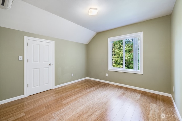 bonus room with light wood-type flooring and lofted ceiling