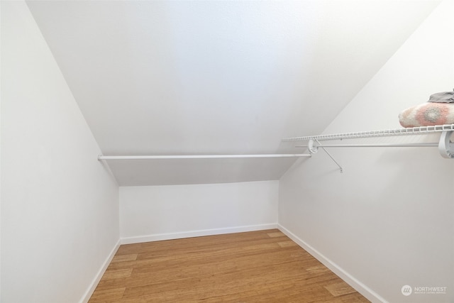 walk in closet featuring wood-type flooring and lofted ceiling