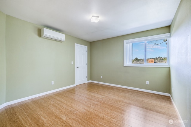 empty room with light hardwood / wood-style floors and a wall mounted air conditioner