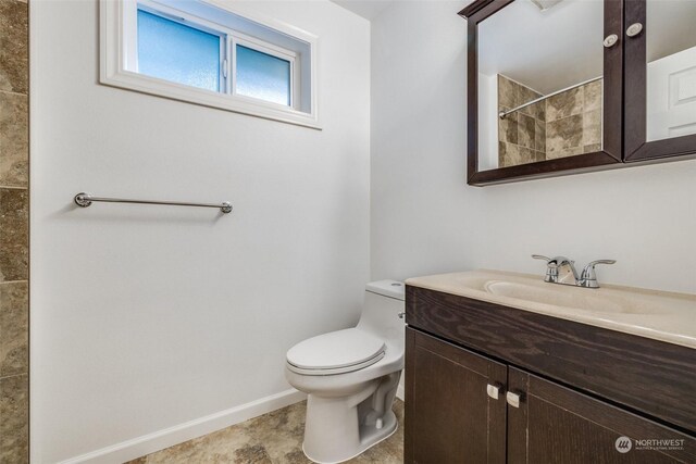 bathroom with a shower, tile patterned flooring, vanity, and toilet