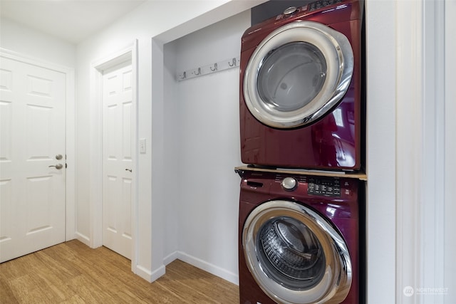 washroom with light hardwood / wood-style flooring and stacked washing maching and dryer