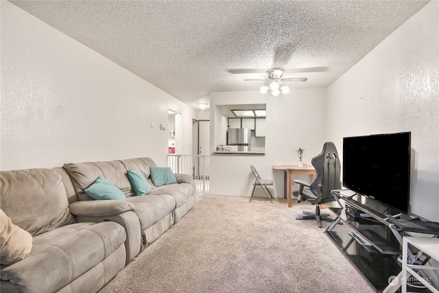 living room with a textured ceiling, a textured wall, ceiling fan, and carpet flooring