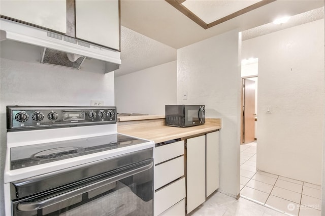 kitchen with electric range, white cabinets, light countertops, under cabinet range hood, and black microwave