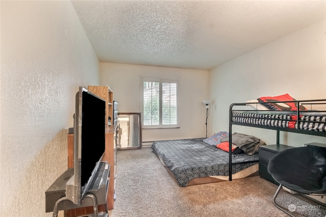 carpeted bedroom with a textured ceiling and a textured wall