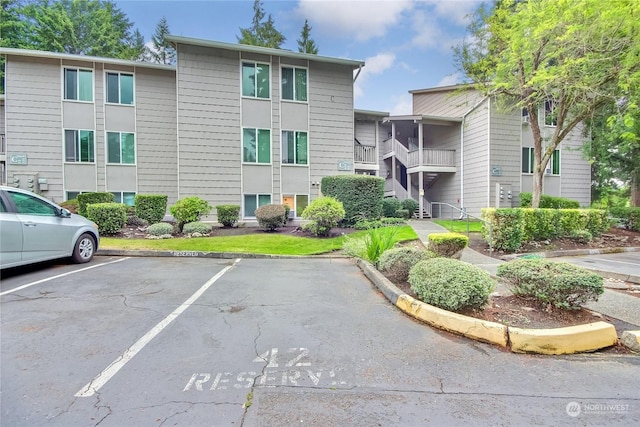 view of property with uncovered parking and a residential view