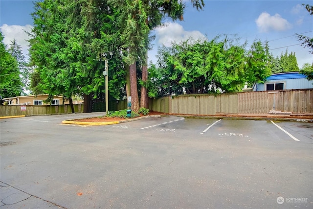 uncovered parking lot featuring fence