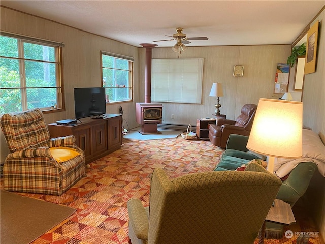 carpeted living area with a wood stove, baseboard heating, and a ceiling fan