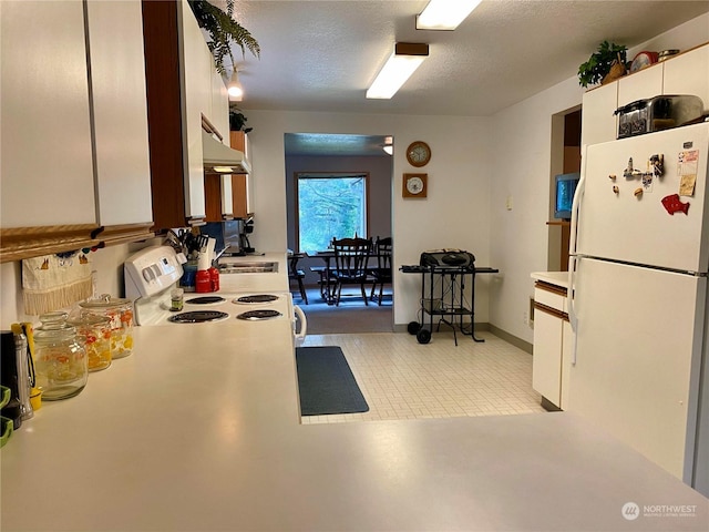 kitchen with light countertops, white appliances, under cabinet range hood, and white cabinets