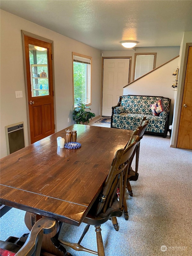 carpeted dining room with a textured ceiling