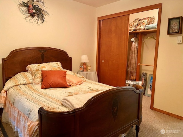 bedroom with a closet, light colored carpet, and baseboards