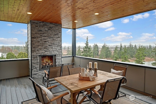 balcony featuring a stone fireplace and a water view