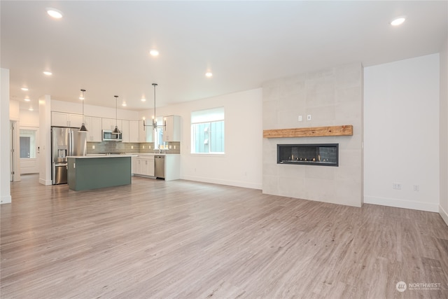 unfurnished living room with light wood-type flooring and a fireplace