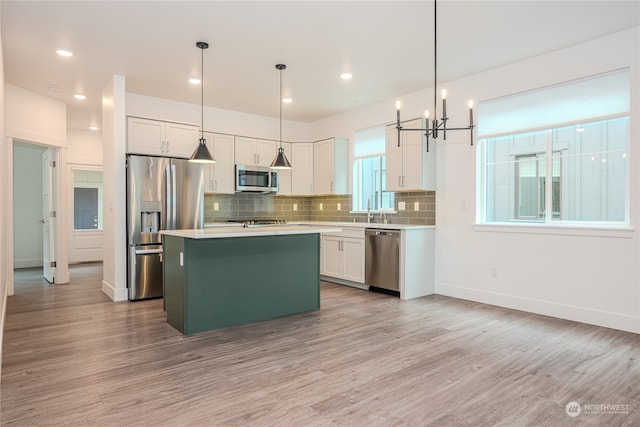 kitchen with appliances with stainless steel finishes, light wood-type flooring, and plenty of natural light