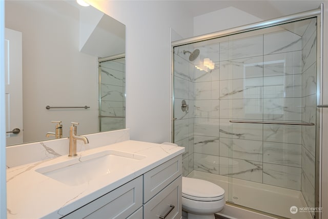 bathroom with a shower with shower door, vanity, and toilet