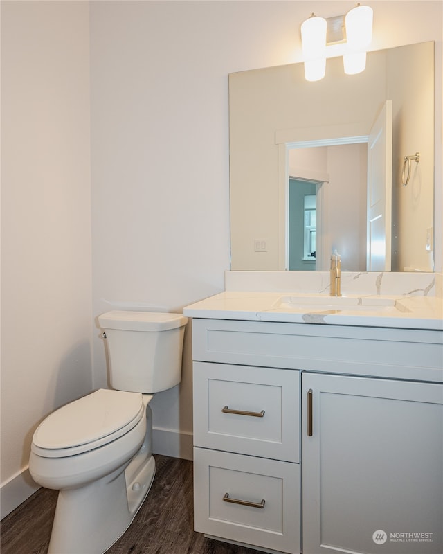 bathroom featuring hardwood / wood-style flooring, vanity, and toilet