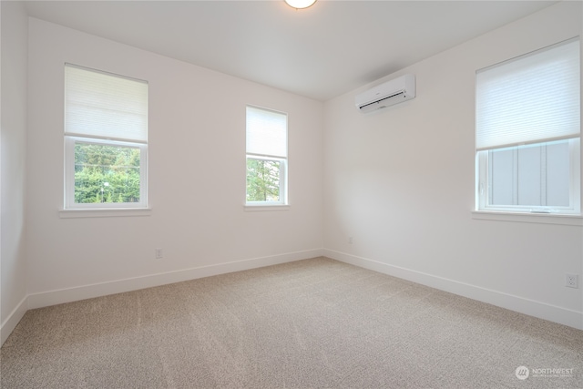 carpeted spare room featuring a wall unit AC