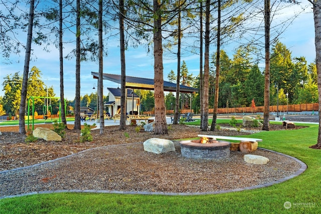 surrounding community with a playground, a fire pit, a gazebo, and a lawn