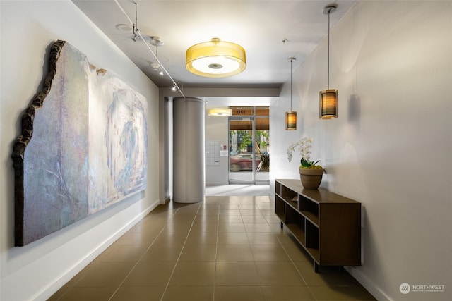 corridor with track lighting and tile patterned floors