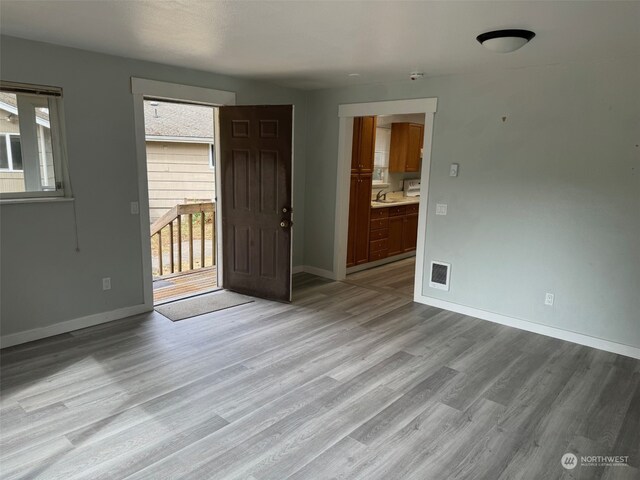 unfurnished room with sink and hardwood / wood-style floors