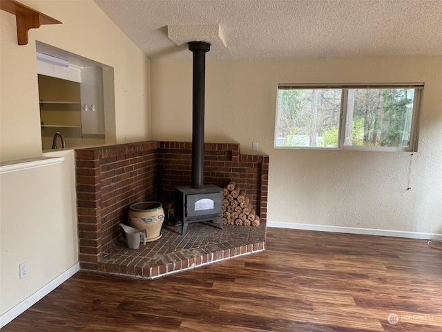 room details featuring a textured ceiling, wood-type flooring, and a wood stove