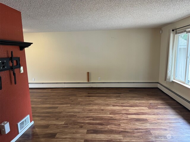 spare room featuring a textured ceiling and hardwood / wood-style floors