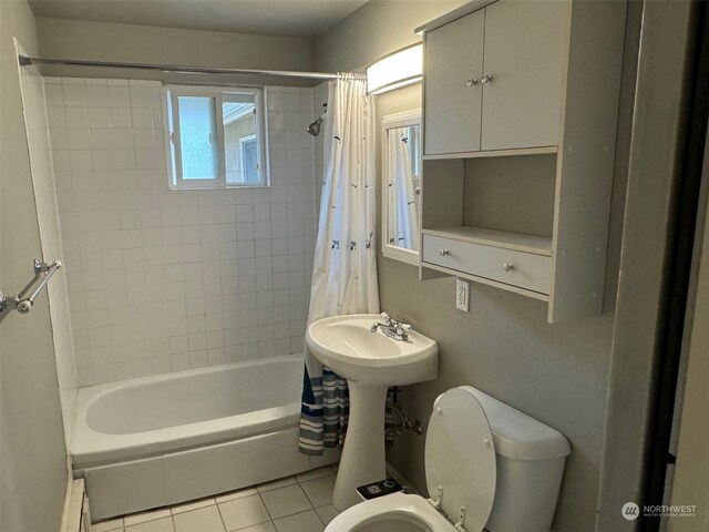 bathroom with tile patterned flooring, shower / tub combo with curtain, and toilet