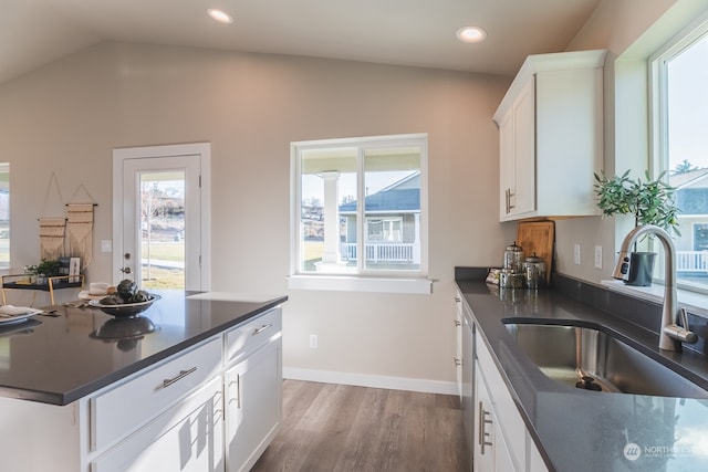 kitchen with white cabinets, lofted ceiling, sink, and hardwood / wood-style floors