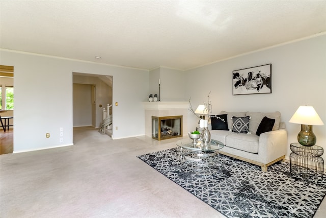 carpeted living room with ornamental molding and a fireplace