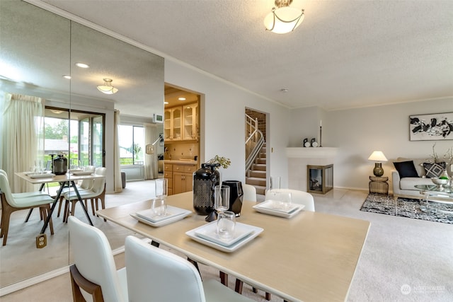 carpeted dining space with a textured ceiling, crown molding, and a multi sided fireplace