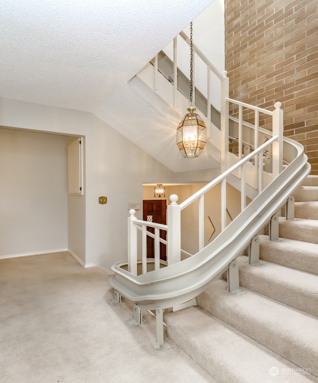 stairs featuring vaulted ceiling, an inviting chandelier, a textured ceiling, and carpet flooring