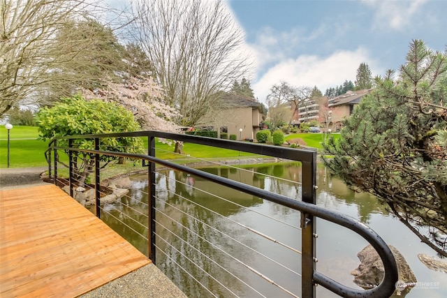 view of dock featuring a yard and a water view