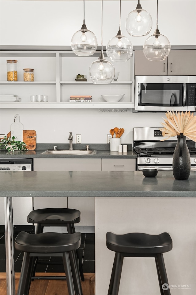 kitchen featuring sink, a kitchen breakfast bar, appliances with stainless steel finishes, and hardwood / wood-style floors